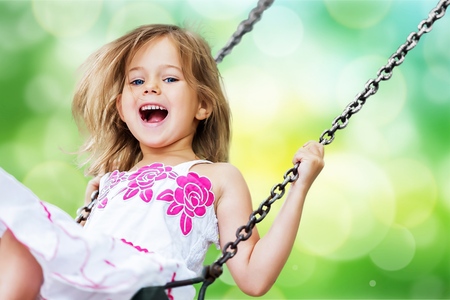 124269562-little-child-blond-girl-having-fun-on-a-swing